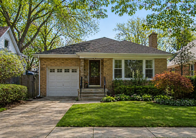 Brick home with a front lawn and mature trees